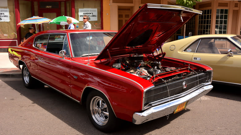 A red Dodge Charger with its hood open