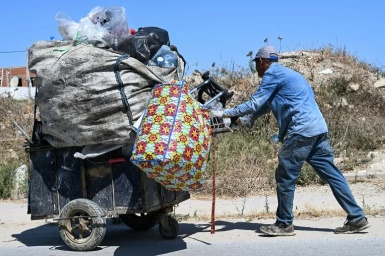 It's common to see people in Tunis weighed down by bags of plastic bottles along the roadside (FETHI BELAID)