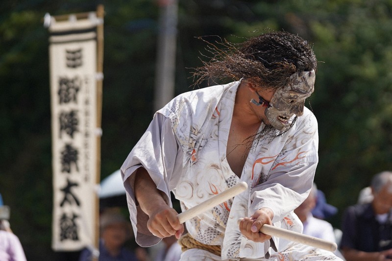 震災の爪痕が残る名舟地区で行われたで名舟大祭。披露された御陣乗太鼓の打ち手たちは迫力がある面を付け太鼓を打つ=石川県輪島市で2025年8月1日午後2時27分、岩本一希撮影