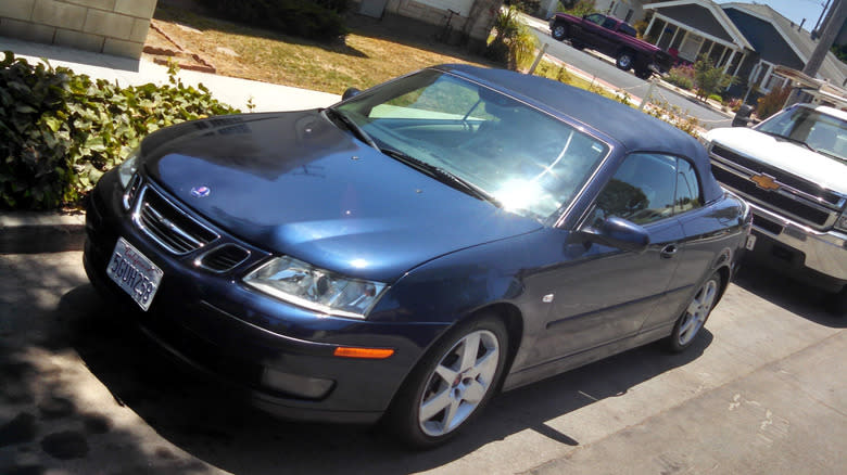 my blue Saab 9-3 convertible parked on a street