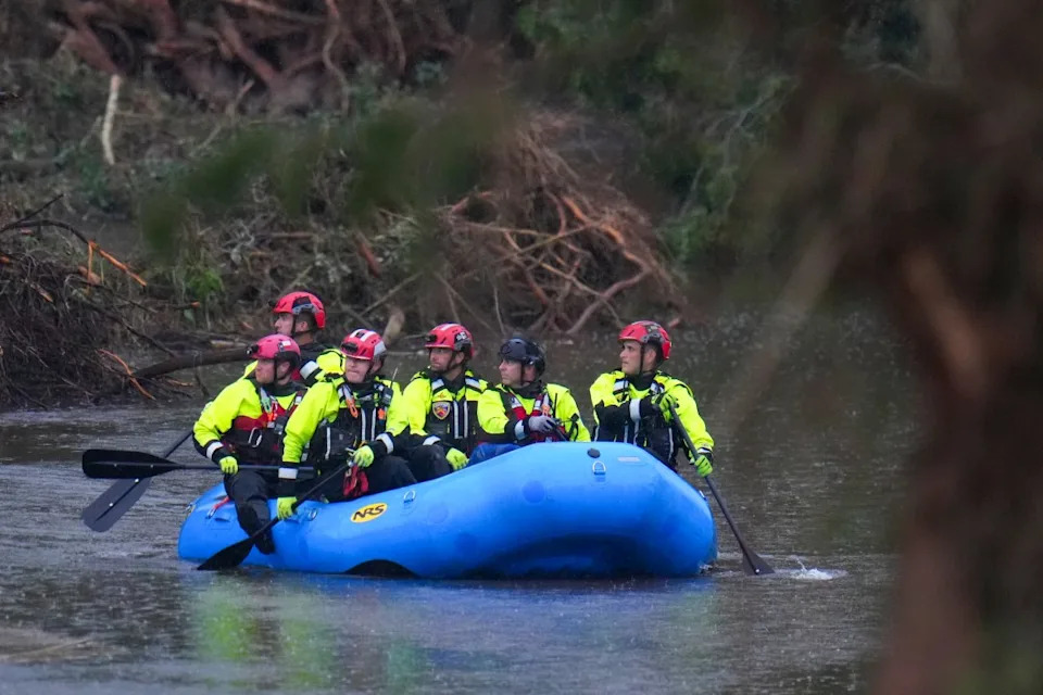 Officials ride a boat in a river