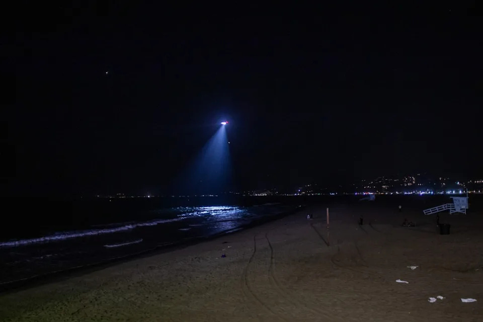 Los Angeles police department helicopter shines spotlight down on beach