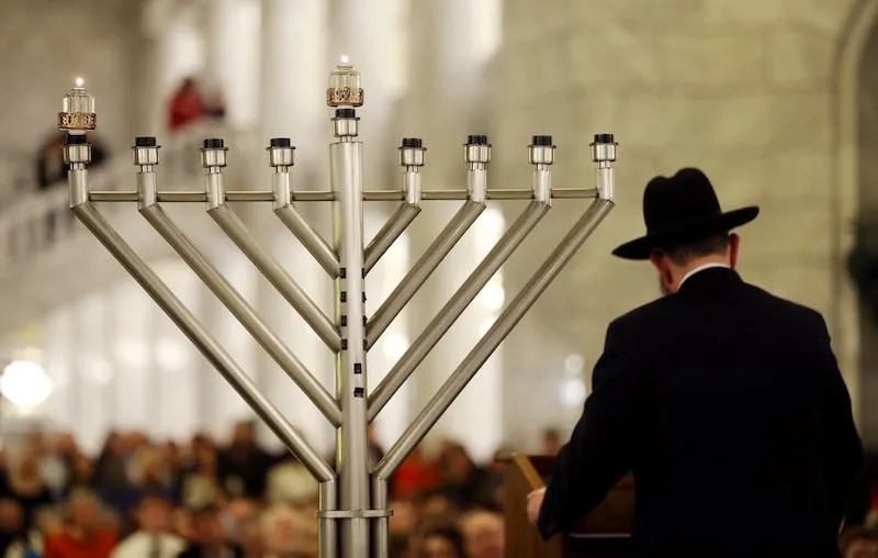 Rabbi Benny Zippel of Chabad Lubavitch of Utah conducts the ceremony as the lighting of a menorah in the state Capitol rotunda marks the first night of Hanukkah in Salt Lake City Sunday, Dec. 22, 2019. | Scott G Winterton, Deseret News