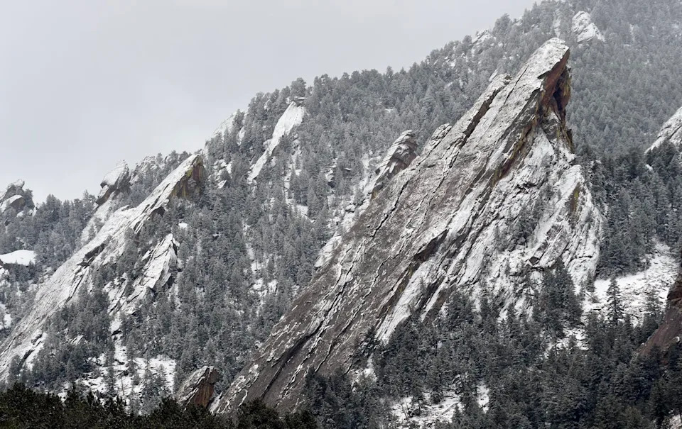 Snow sits on steep rocky slopes.