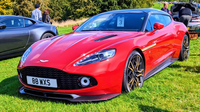 A red Aston Martin Vanquish Zagato Shooting Brake parked on a lawn
