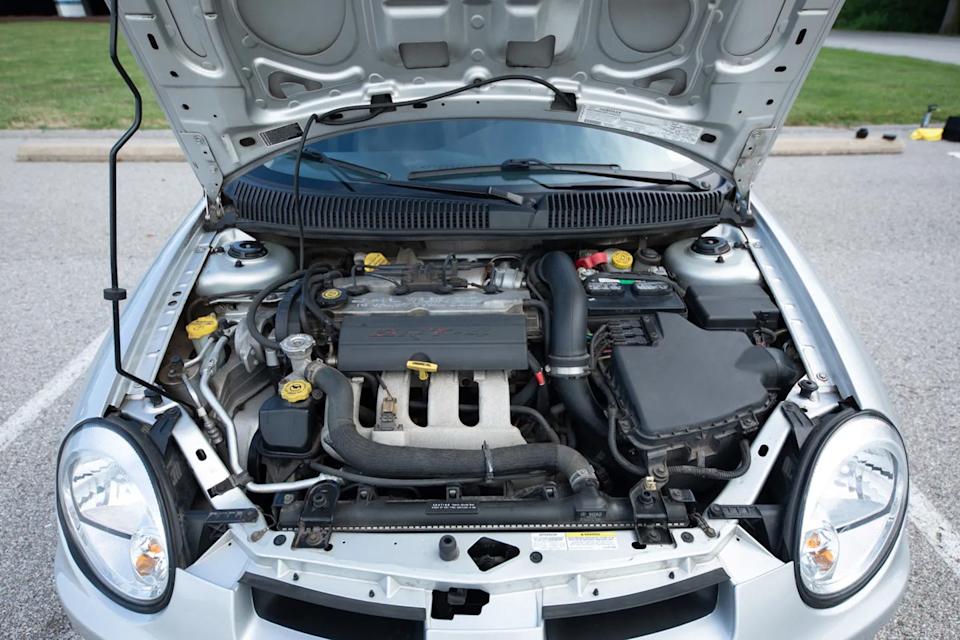 front view of engine bay with hood open showing various components and fluid caps.
