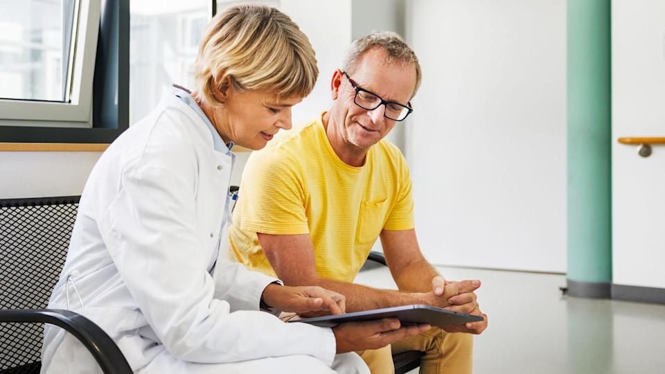 Una médica conversa con un paciente en una consulta.