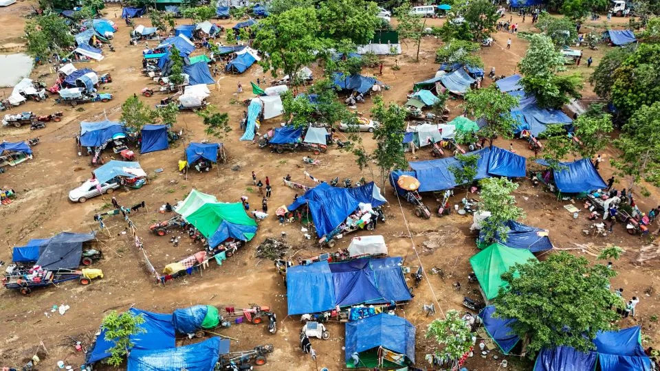 An aerial view shows people, who fled their homes near the border area between Cambodia and Thailand, taking shelter near a pagoda in Oddar Meanchey province on July 26, 2025. - Suy Se/AFP/Getty Images