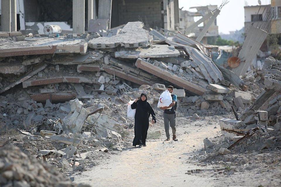 Palestinos buscan entre los escombros de sus casas devastadas alguna pertenencia que aún pueda usarse después del ataque aéreo israelí que tuvo como objetivo varias viviendas.