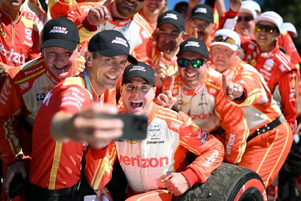 celebratory team selfie with race car drivers and crew in matching uniforms