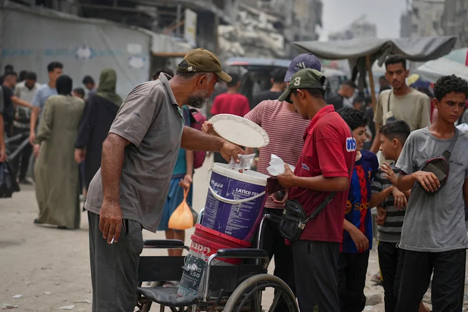 In the summer heat, a man sells plastic bags of water for one shekel each, in Gaza City, Tuesday, Aug. 12, 2025. (AP Photo/Jehad Alshrafi) (AP)