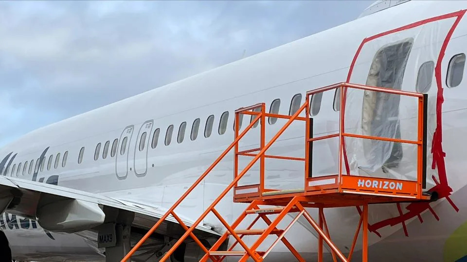 In this National Transportation Safety Board handout, plastic covers the exterior of the fuselage plug area of Alaska Airlines Flight 1282 Boeing 737-9 MAX on January 7, 2024 in Portland, Oregon. - NTSB/Handout/Getty Images