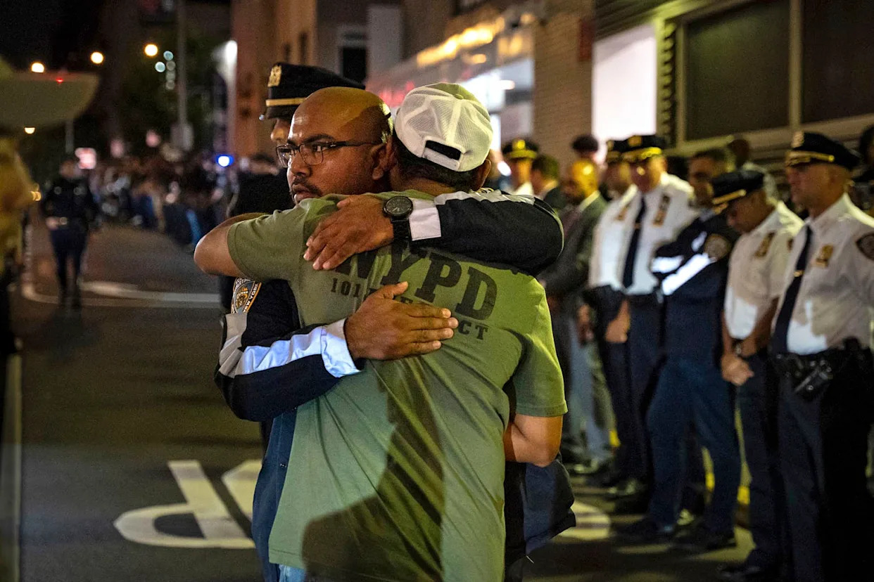 People embrace during the dignified transfer of slain New York police officer Didarul Islam early on July 29, 2025. (Angelina Katsanis / AP)