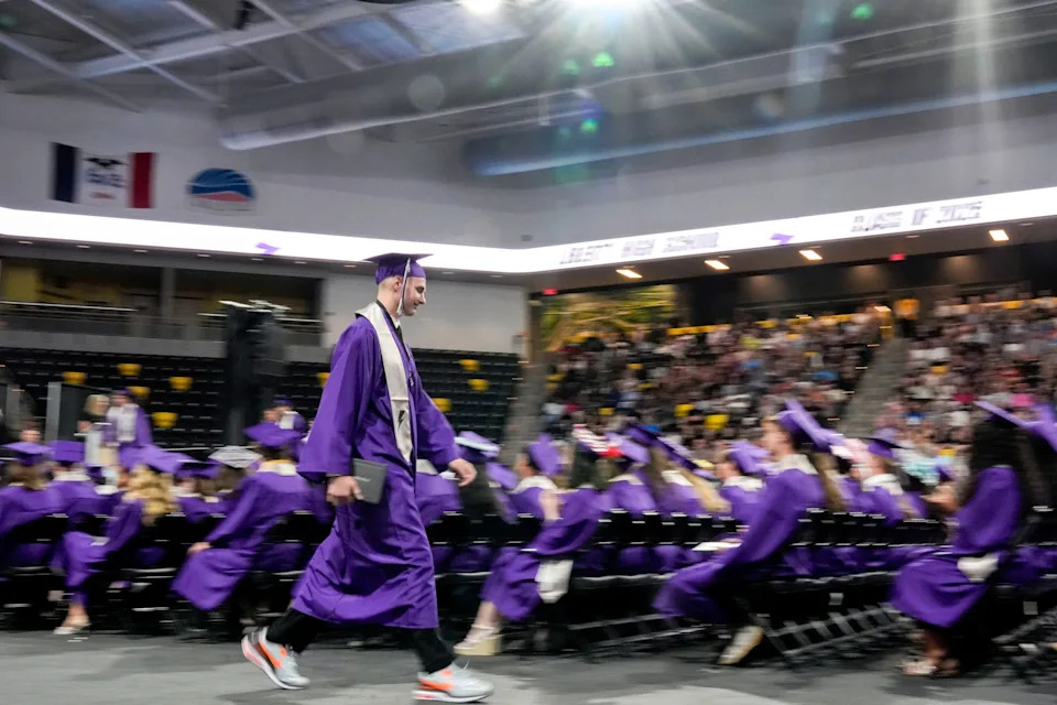 A student walks back to their seat during the Iowa City Liberty graduation ceremony May 31, 2025 at Xtream Arena in Iowa City, Iowa.