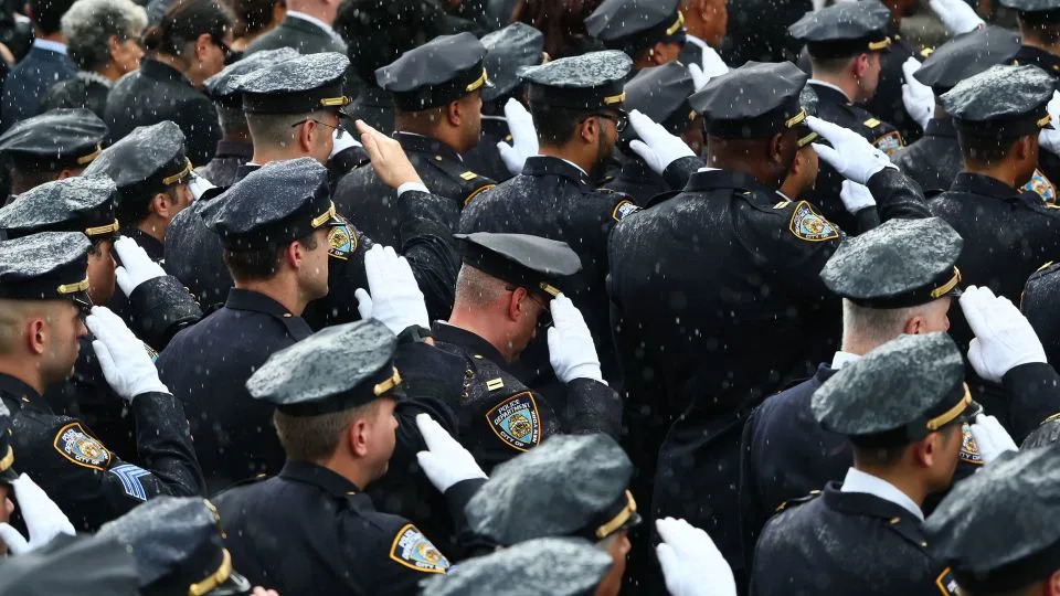 Members of the NYPD and other law enforcement agencies lined the streets during the funeral procession, offering a salute for the slain officer. - Michael M. Santiago/Getty Images