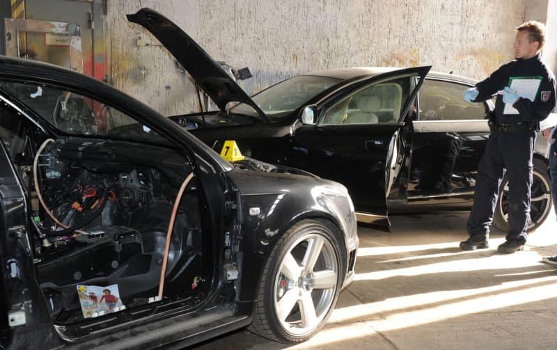 A police officer in a warehouse with stolen cars in Germany. Vehicle parts theft to order is becoming an increasing problem. Bernd Settnik/dpa-Zentralbild/dpa