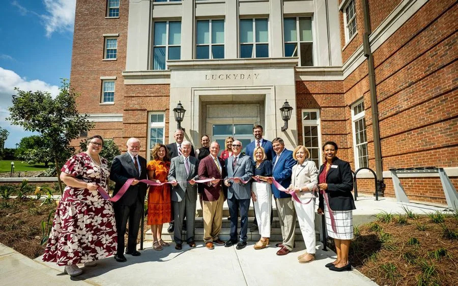 Luckyday Foundation members of the board of managers celebrate Friday [Aug. 8] during Azalea Hall’s ribbon cutting. The student residence hall includes a living and learning community for MSU’s Luckyday Scholars program. Pictured, from left, front row: MSU Vice President for Student Affairs Regina Hyatt; former Luckyday Foundation Chair Holmes Adams; Mary Preston Dubberly; Granville Tate; MSU President Mark E. Keenum; Luckyday Foundation Chair Jamie Houston; Luckyday Foundation Secretary Kristin Merrell; Luckyday Foundation Vice Chair Jerry Host; Luckyday Foundation Executive Director Patricia Smith; and MSU Executive Director of Housing and Residence Life Dei Allard; back row: MSU Executive Director of the Center for Academic Excellence Clay Armstrong; MSU Luckyday Scholars Program Coordinator Hadley Howell; MSU Luckyday Scholars Program Director Tiffany Key; and MSU Foundation Senior Director of Corporate and Foundation Relations Alex McIntosh. (Photo by Grace Cockrell via Mississippi State University)