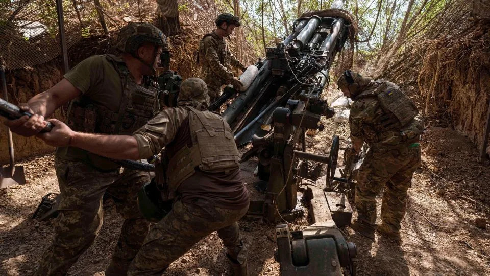 Ukrainian servicemen of the 148th artillery brigade load ammunition into a M777 howitzer before firing towards Russian positions at the frontline in Zaporizhzhia region, Ukraine, on Thursday, Aug. 7, 2025. - Evgeniy Maloletka/AP