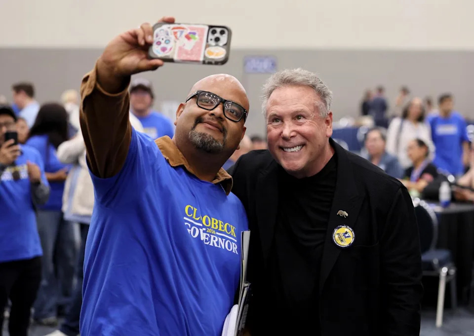 Philanthropist and businessman Stephen Cloobeck, right, takes a photo with a supporter