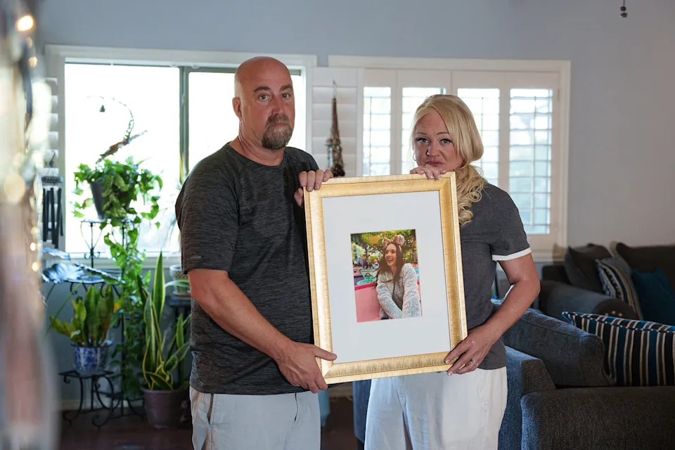 Tom and Erika Pillsbury hold a picture of their late daughter, Mercedes Vega as they pose for a portrait in their living room on (Megan Mendoza / USA Today Network via Reuters file)