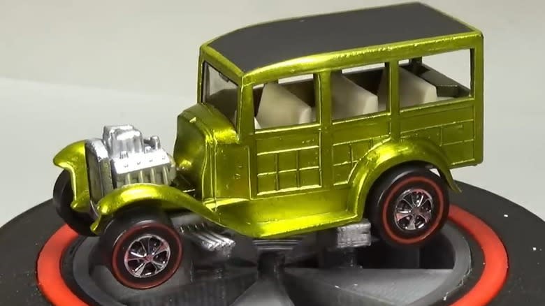 A Classic '31 Ford Woody in a golden color sitting on a white background.