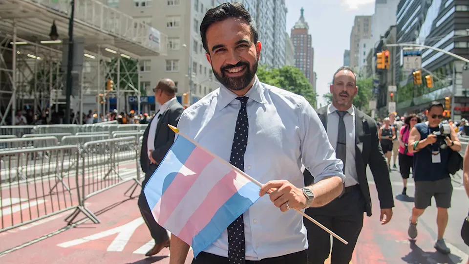 Zohran Mamdani at pride event, holding transgender pride flag
