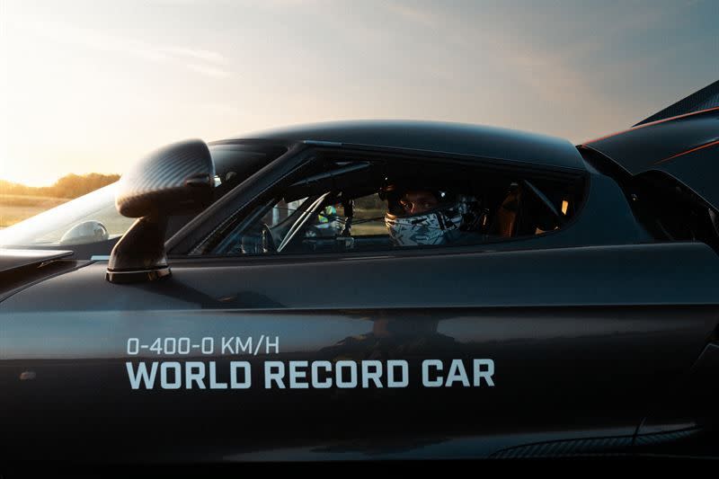side view of a highperformance car with a driver wearing a helmet labeled as a world record car