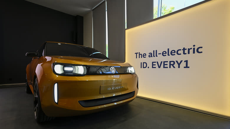 the ev ID Every1 concept. A small, gold colored car sits in front of a screen that reads "The all-electric ID. EVERY1"