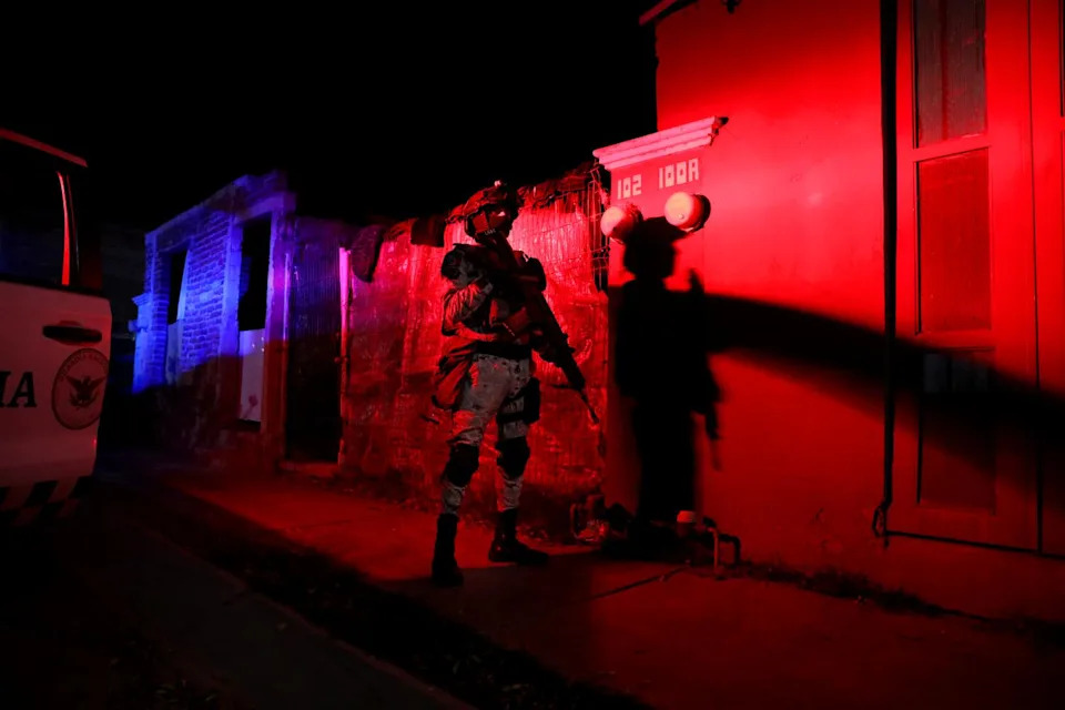 A national guardsman stands outside a building.