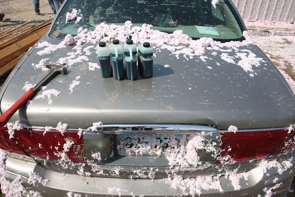 Fiber glass insulation covers cars, buildings and grass on Tuesday, July 29, 2025 after a warehouse roof was blown off by a wind storm that moved through the area on Monday evening. The system damaged trees, homes and other structures. (Makenzie Huber/South Dakota Searchlight)