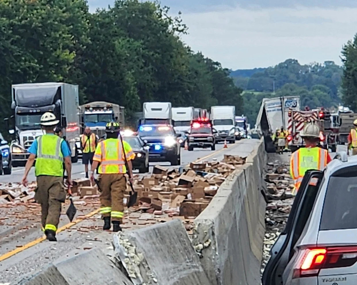<span>Rescue crews clean up a truckload of spilled hotdogs in Pennsylvania.</span><span>Photograph: AP</span>