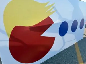 Support for former President Donald Trump created a sign of his avatar with hair eating the Democrats’ blue dot in Nebraska’s 2nd Congressional District. (Aaron Sanderford/Nebraska Examiner)