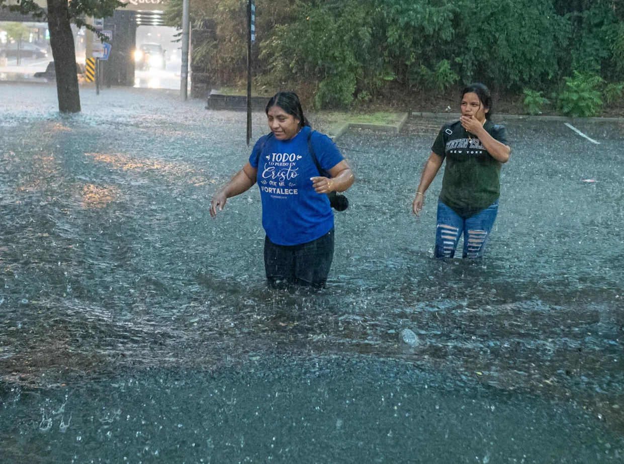 <span>Women wade through the raging flood waters on Watchung Avenue in Plainfield, New Jersey on 14 July 2025.</span><span>Photograph: Brian Branch Price/Zuma Press Wire/Shutterstock</span>