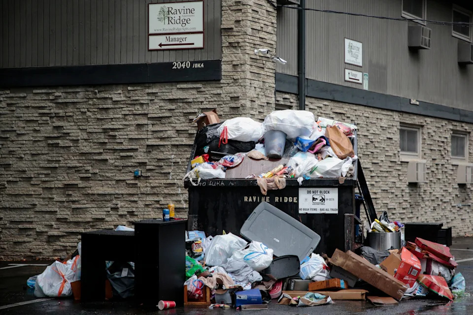 Trash overflows a dumpster near an apartment complex north of 19th Ave., near Summit St., on Tuesday, July 31, 2018. Ohio State University, the University District and the city's Division of Refuse Collection are partnering to avoid avoid trash piling up around off-campus housing as students' leases have expired.