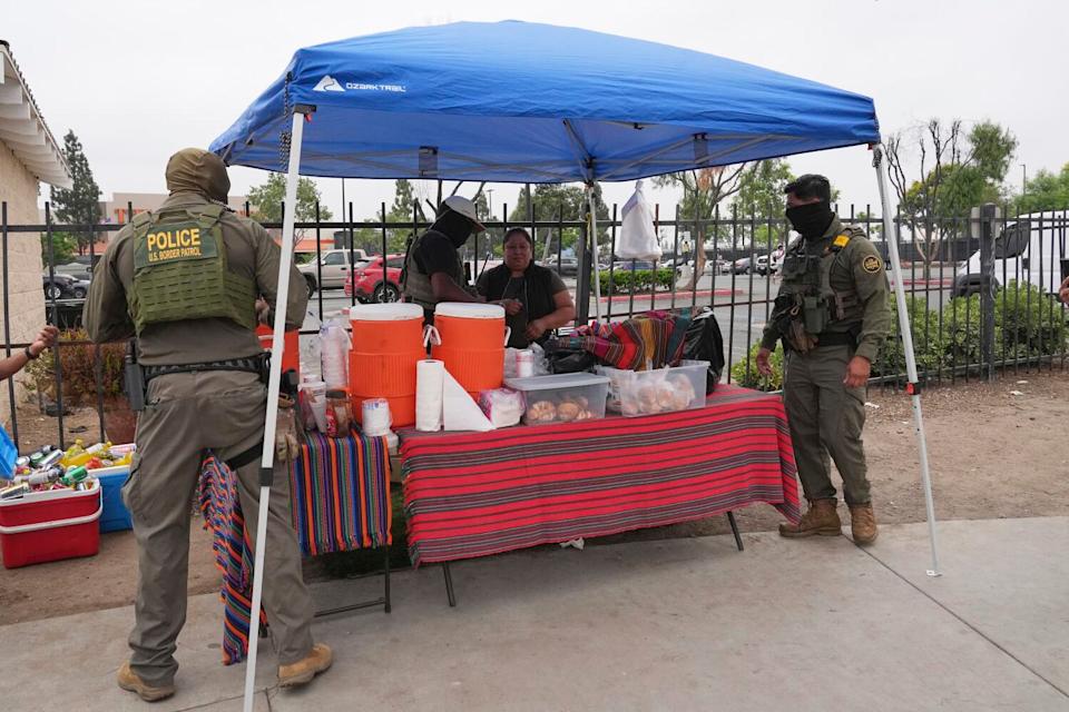 A woman is detained by U.S. Border Patrol agents outside a Home Depot