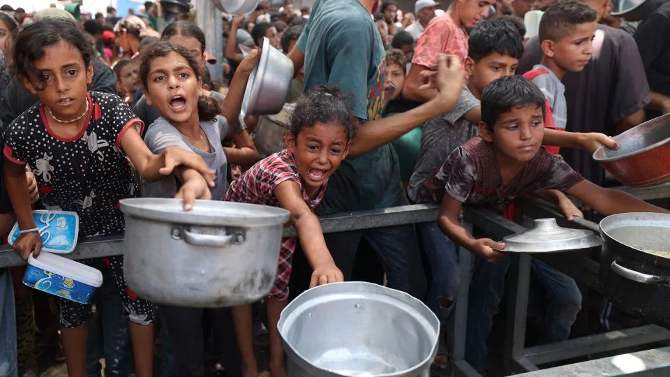 Palestinians gather at a food distribution center in the Nuseirat refugee camp in the central Gaza Strip on Monday. - Eyad Baba/AFP/Getty Images