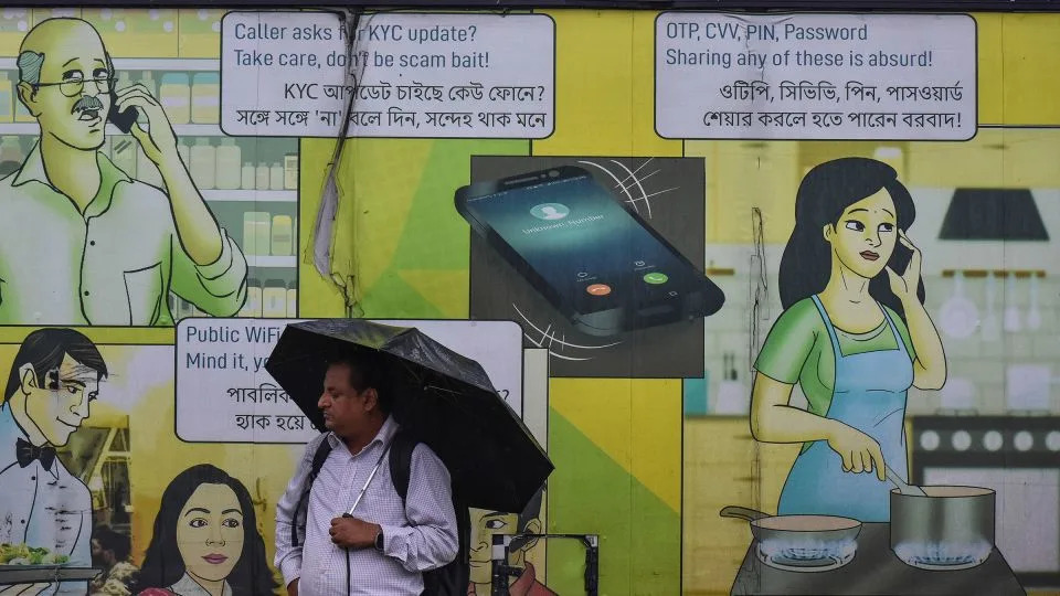 A man stands in front of a cyber crime awareness billboard, with warnings in both English and Bengali, in Kolkata, Bengal, India, on July 9. - Debarchan Chatterjee/NurPhoto/Associated Press