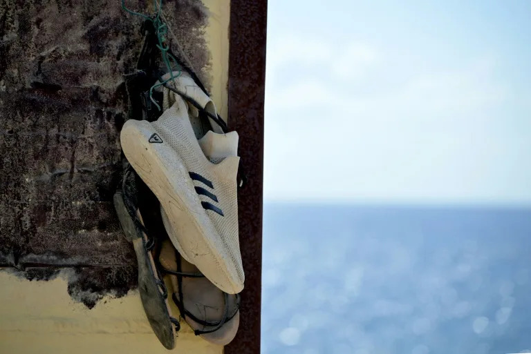 Shoes hanging on the "Porta di Lampedusa" monument, known as "The door of Europe", dedicated to the migrants who have died in the Mediterranean sea trying to reach Europe, on September 25, 2023 on the Italian island of Lampedusa (Tiziana FABI)