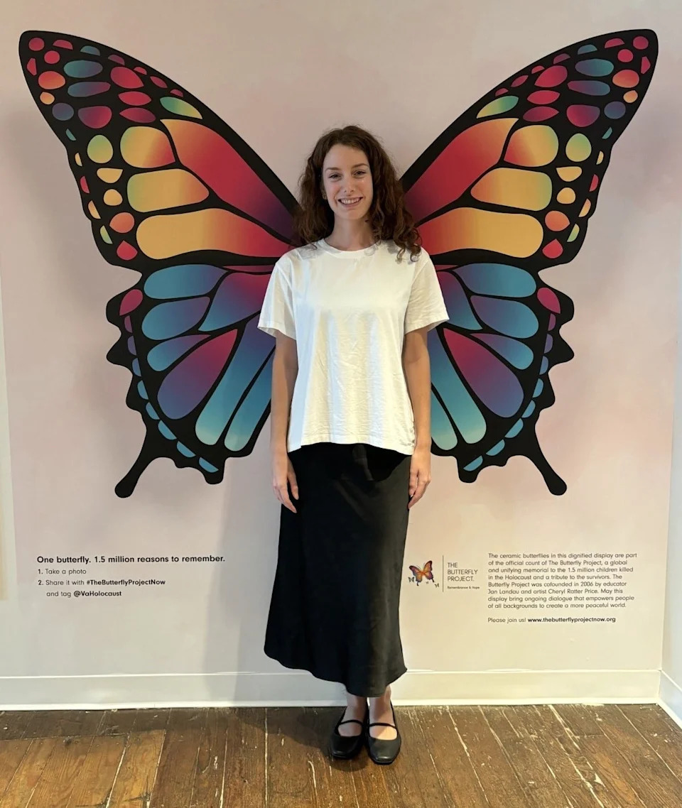 Kate Adams, director of public and student programs at Virginia Holocaust Museum in Richmond, poses with the new butterfly mural. It encourages engagement with The Butterfly Project, a global initiative honoring the 1.5 million children murdered during the Holocaust.