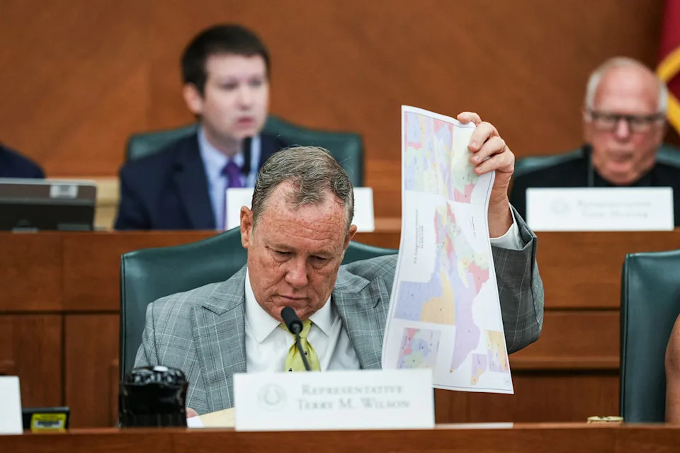 Terry M. Wilson looks through maps during a public hearing (Eric Gay / AP)