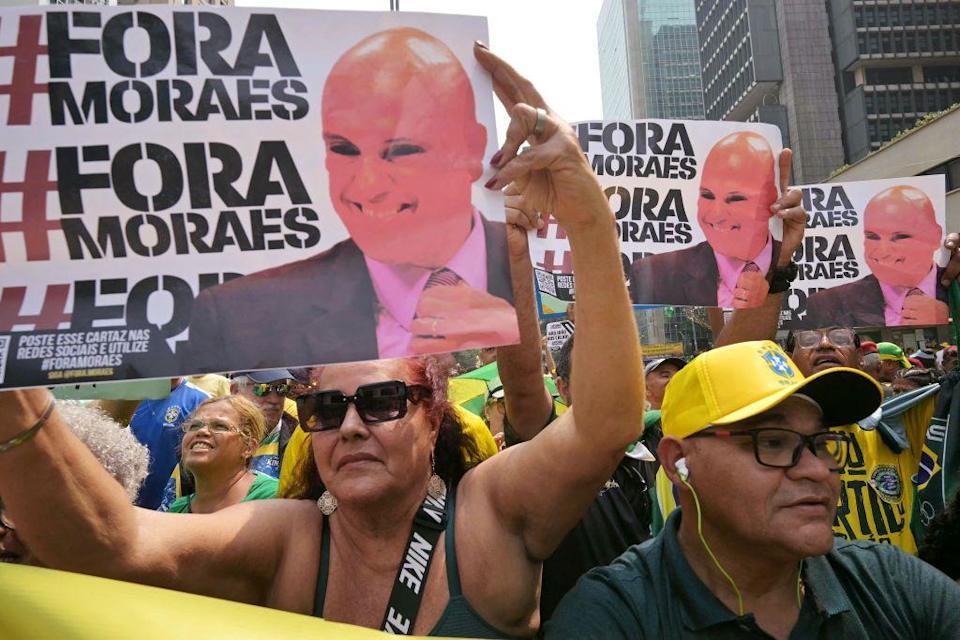Seguidores de Bolsonaro con carteles que leen