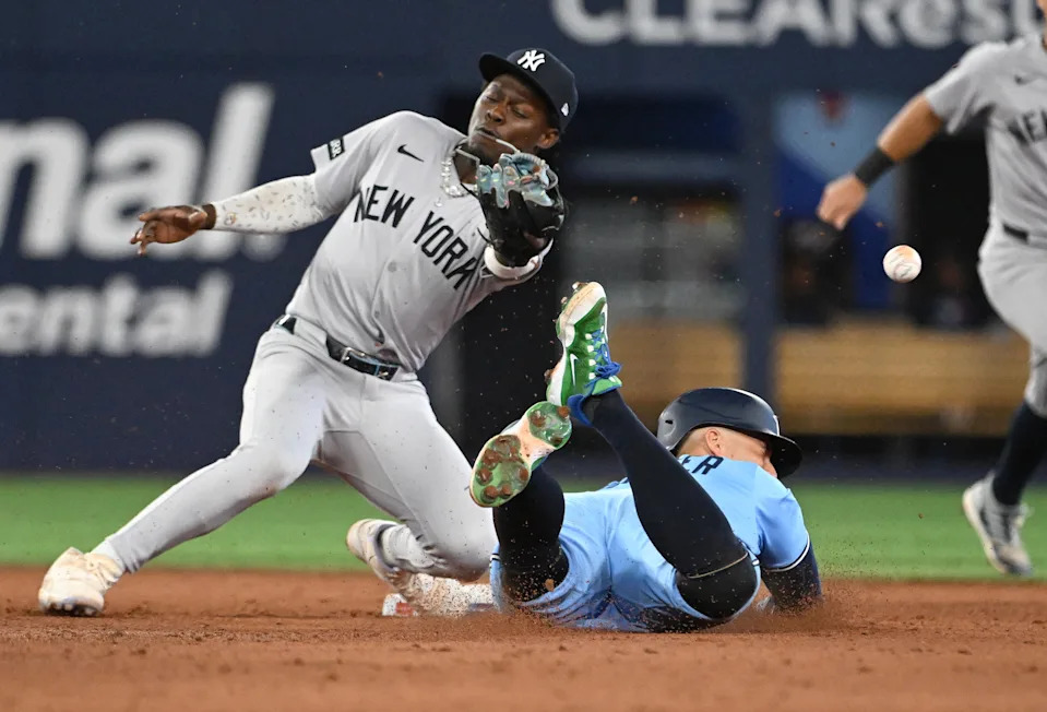 Jul 23, 2025; Toronto, Ontario, CAN; Toronto Blue Jays designated hitter George Springer (4) steals second base as New York Yankees second baseman Jazz Chisholm Jr. (13) misses the throw in the eighth inning at Rogers Centre. Mandatory Credit: Dan Hamilton-Imagn Images