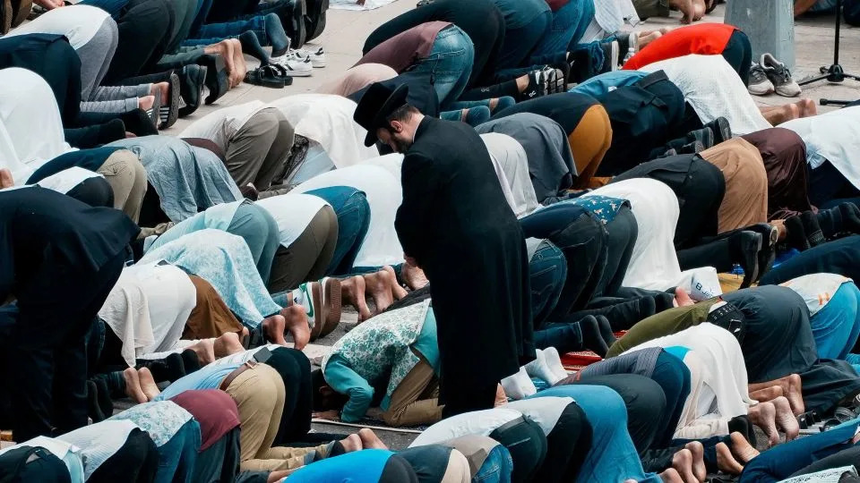 Community members bow in prayer during the funeral services Thursday. - Eduardo Munoz/Reuters