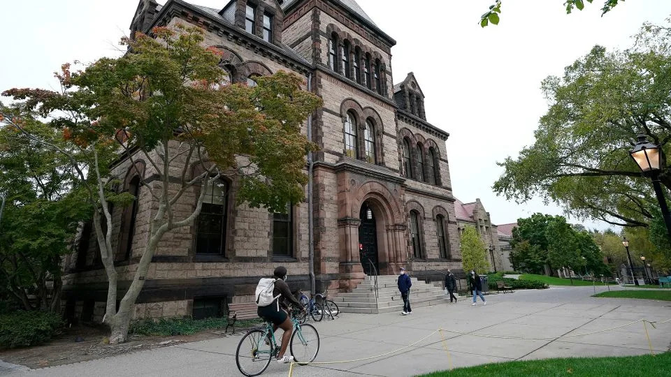 People travel through Brown University&#39;s campus in Providence, Rhode Island, in October 2020. - Steven Senne/AP/File