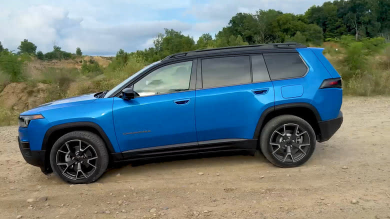 side view of the blue 2026 Cherokee Overland driving on dirt