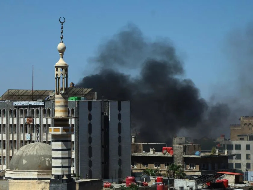Smoke billows during clashes in the predominantly Druze city of Sweida