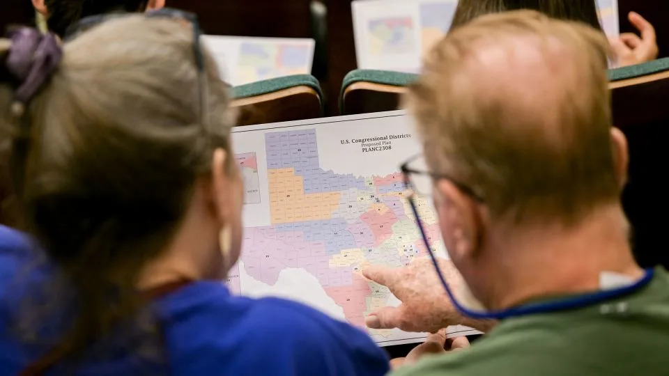 Attendees at an August 7 hearing by the Senate Special Committee on Congressional Redistricting in Austin, Texas, look at a map of the state. - Brandon Bell/Getty Images