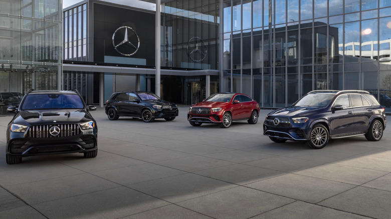 Four 2024 Mercedes-AMG GLE 63 S SUVs in front of a Mercedes-Benz building