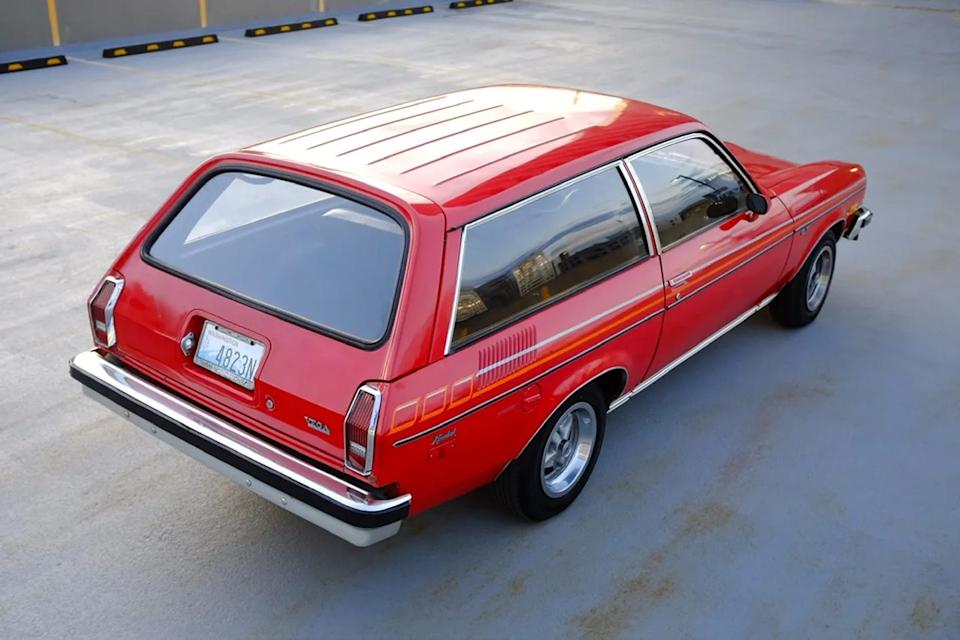 rear three quarter view of red two door wagon with vertical taillights and washington license plate parked in rooftop lot.