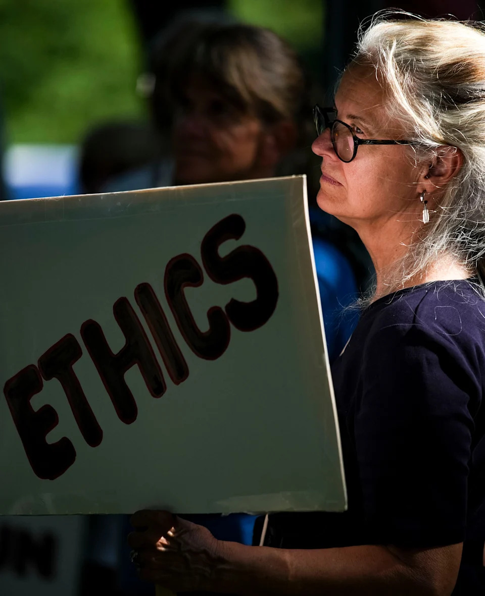 Patricia Ray of Westfield holds up a sign toward cars driving by Thursday, Aug. 7, 2025, outside of the Indiana Governor’s residence on North Meridian Street in Indianapolis. Around 300 stood on the sidewalk to object to the idea of a special session for redistricting in Indiana.